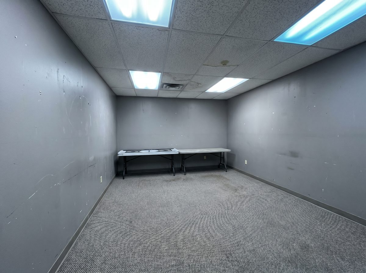 Dated commercial office with gray walls and fluorescent lights — before commercial repaint